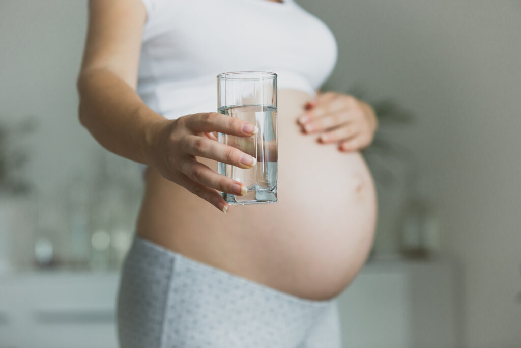 closeup of pregnant woman holding glass of water 2021 12 14 00 36 43 utc